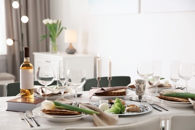 Photo of Festive Passover table setting with Torah at home. Pesach celebration