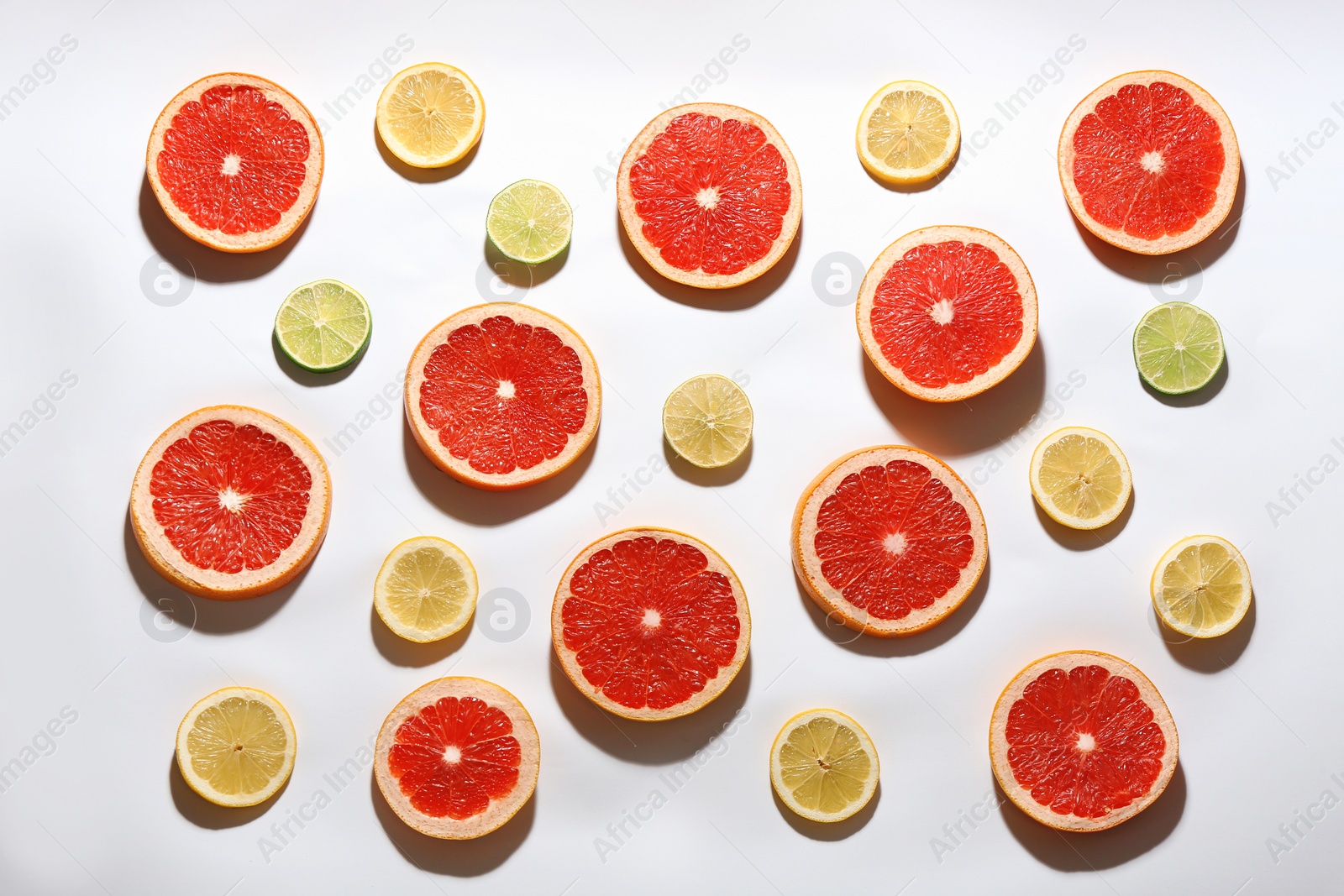 Photo of Flat lay composition with tasty ripe grapefruit slices on white background