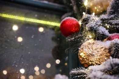 Photo of Beautiful decorative garland with Christmas balls on blurred background, closeup