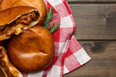 Photo of Delicious baked patties with cabbage and rosemary branches on wooden table, top view. Space for text