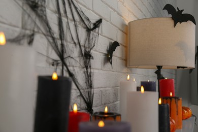 Photo of Burning candles and different Halloween decor indoors