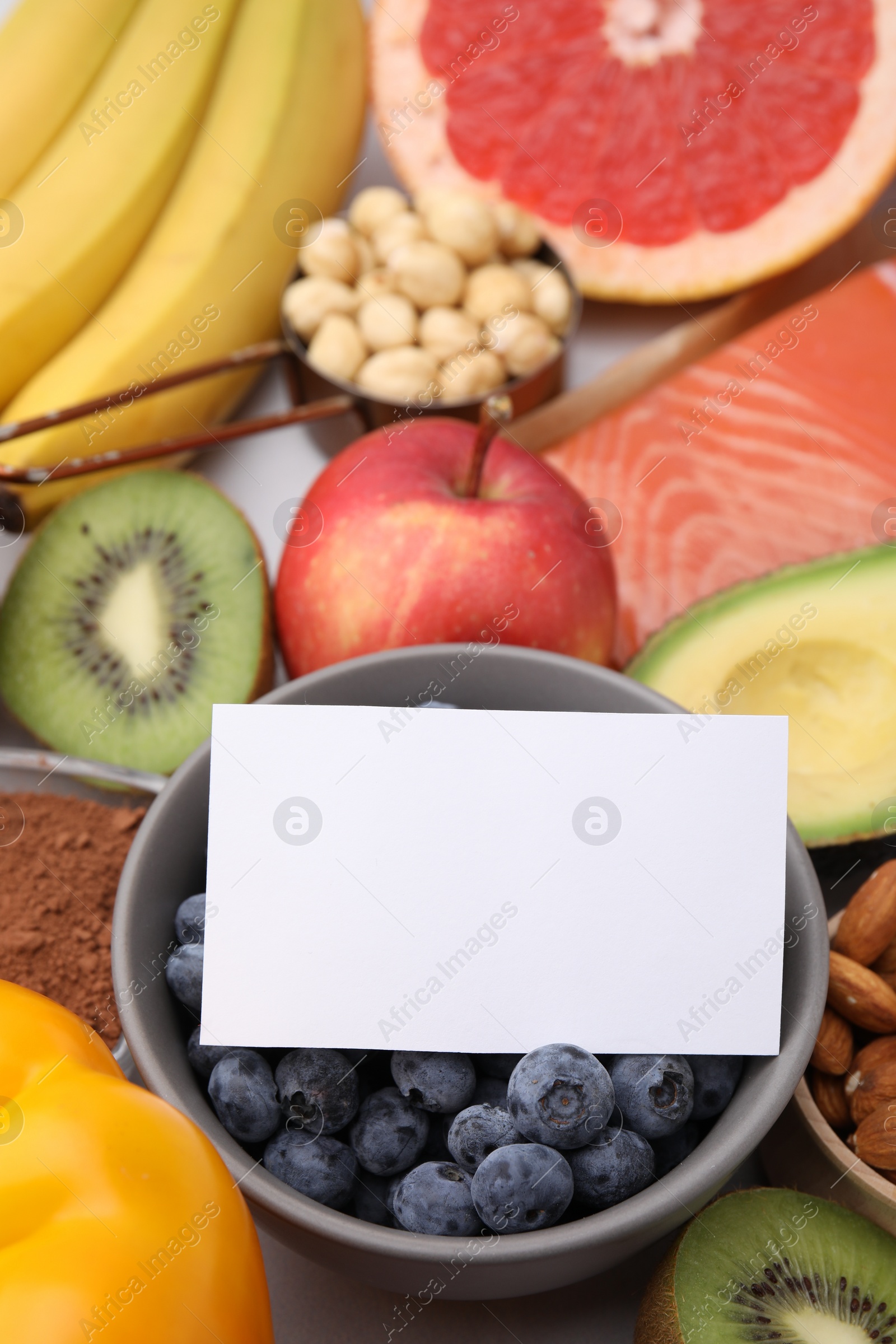 Photo of Many different products and blank card on white table, space for text. Natural sources of serotonin