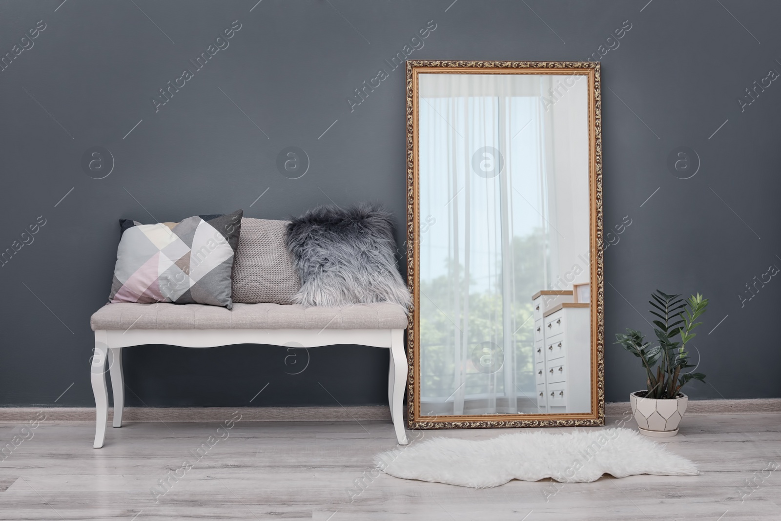 Photo of Elegant room interior with large mirror and bench