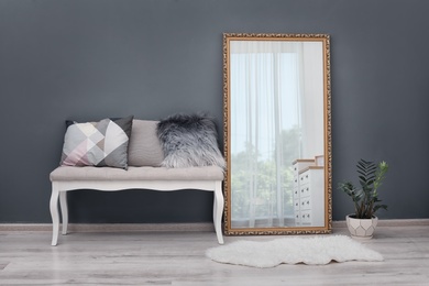Photo of Elegant room interior with large mirror and bench