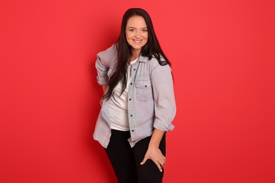 Beautiful overweight woman with charming smile on red background