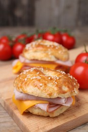 Photo of Delicious bagels with ham and cheese on table