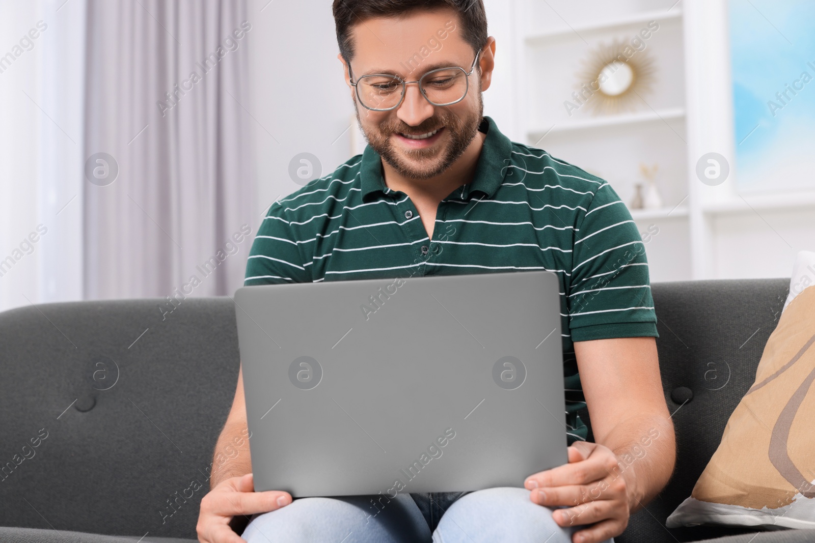 Photo of Happy man having video chat via laptop at home