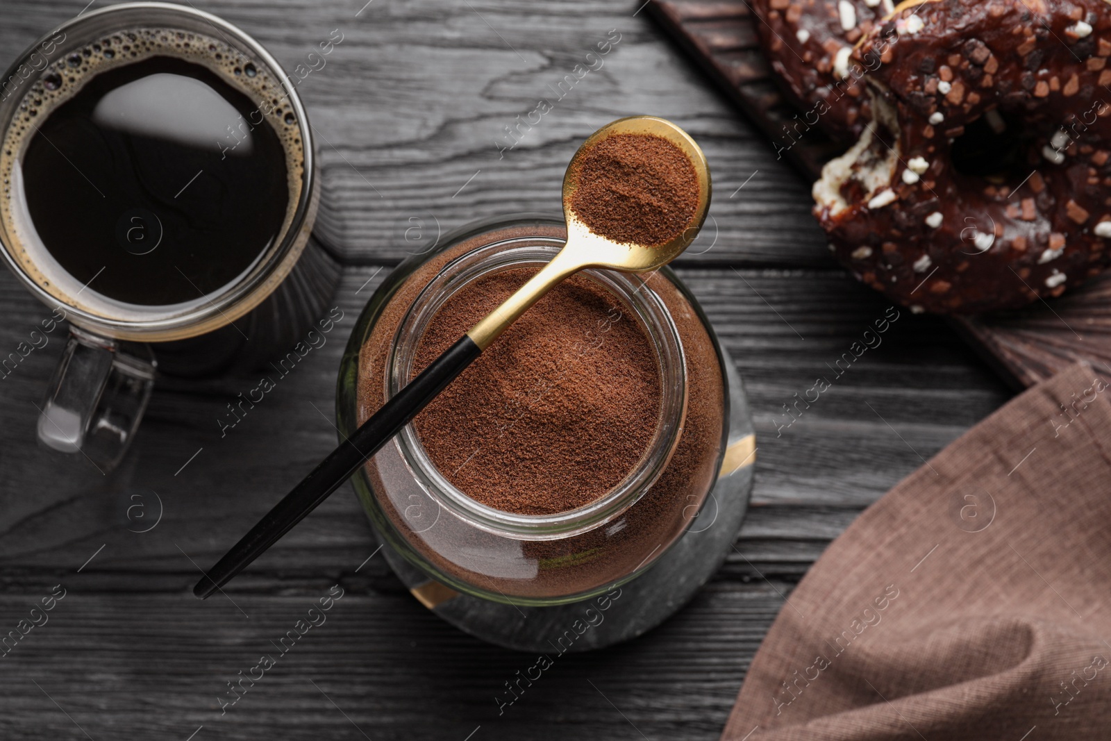 Photo of Flat lay composition with instant coffee on black wooden table