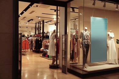 Beautiful clothes on mannequins in showcases of fashion store