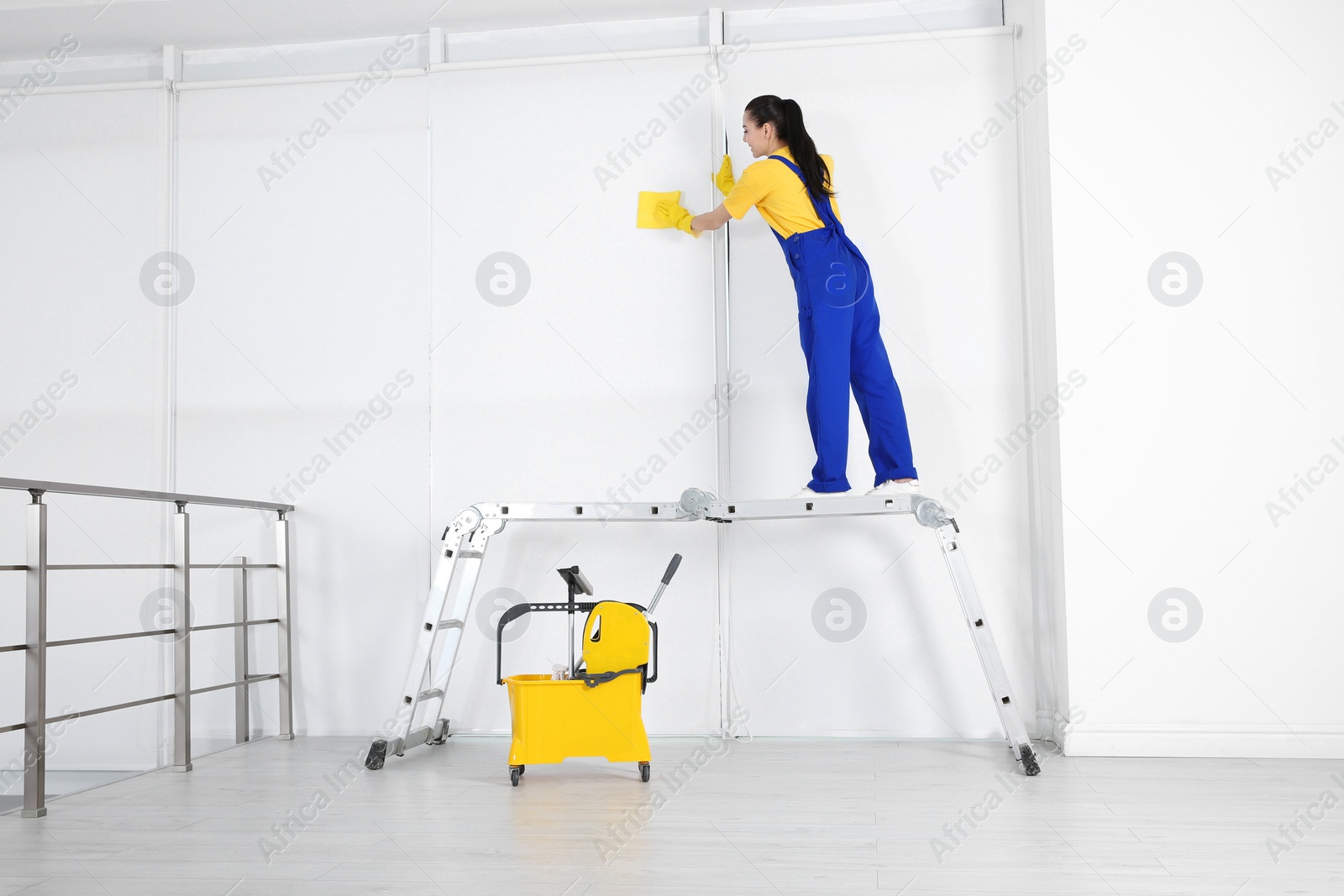 Photo of Professional janitor cleaning wall with rag after renovation