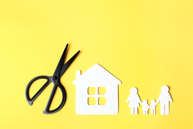 Photo of Flat lay composition with paper silhouette of family and scissors on color background. Life insurance concept