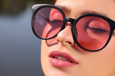 Beautiful woman in sunglasses outdoors, closeup. Space for text