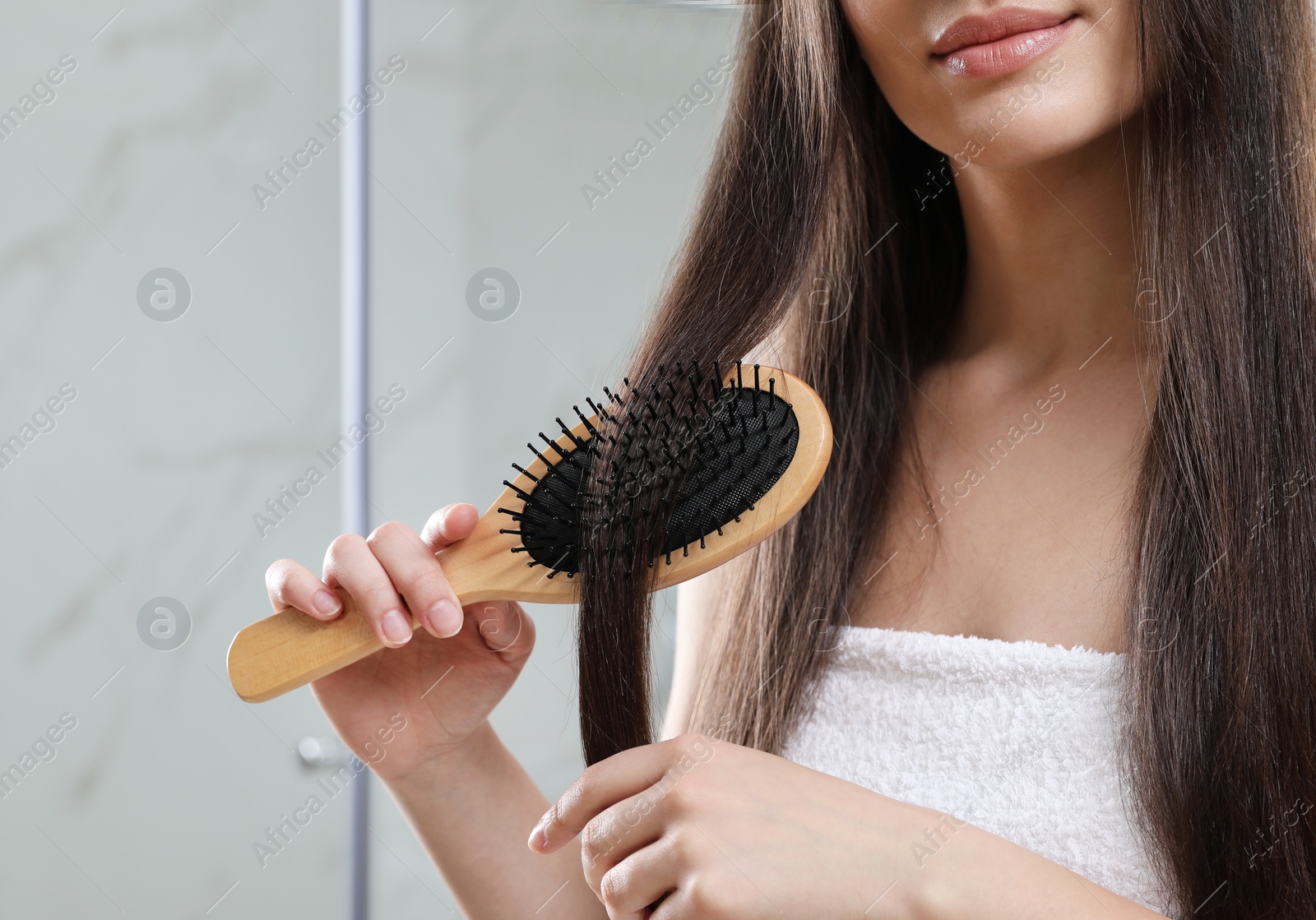 Photo of Young woman with hair brush in bathroom, closeup view