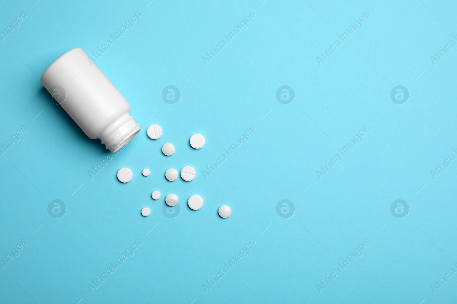 Photo of Container with white pills on color background, flat lay