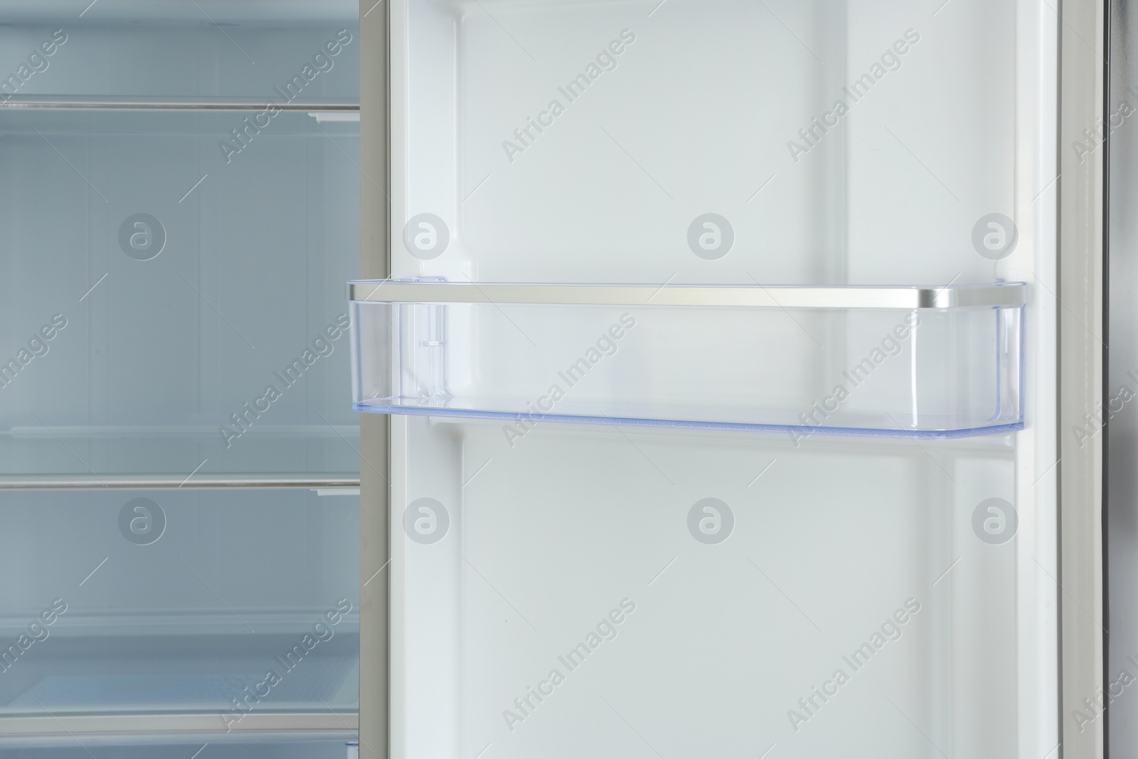 Photo of Door shelf of empty modern refrigerator, closeup view