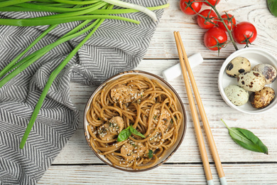 Photo of Tasty buckwheat noodles with meat served on white wooden table, flat lay