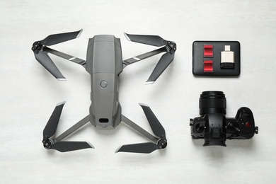 Photo of Modern drone, camera and video production equipment on white table, flat lay