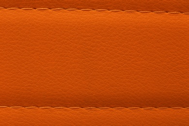 Texture of orange leather as background, top view