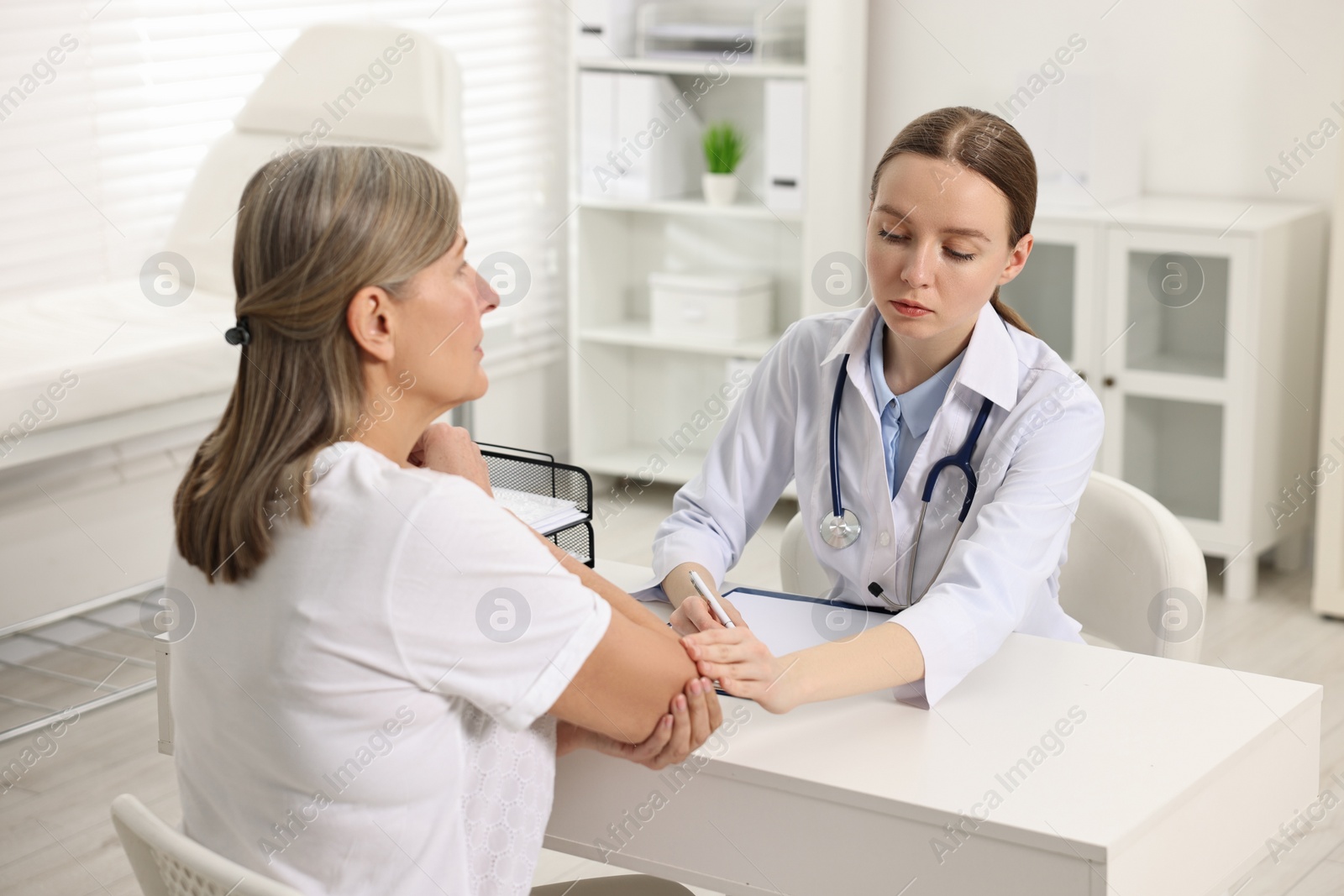 Photo of Arthritis symptoms. Doctor examining patient's elbow in hospital