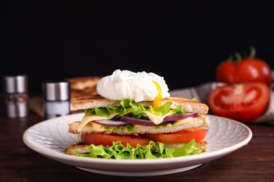 Photo of Tasty sandwich with poached egg on wooden table. Space for text