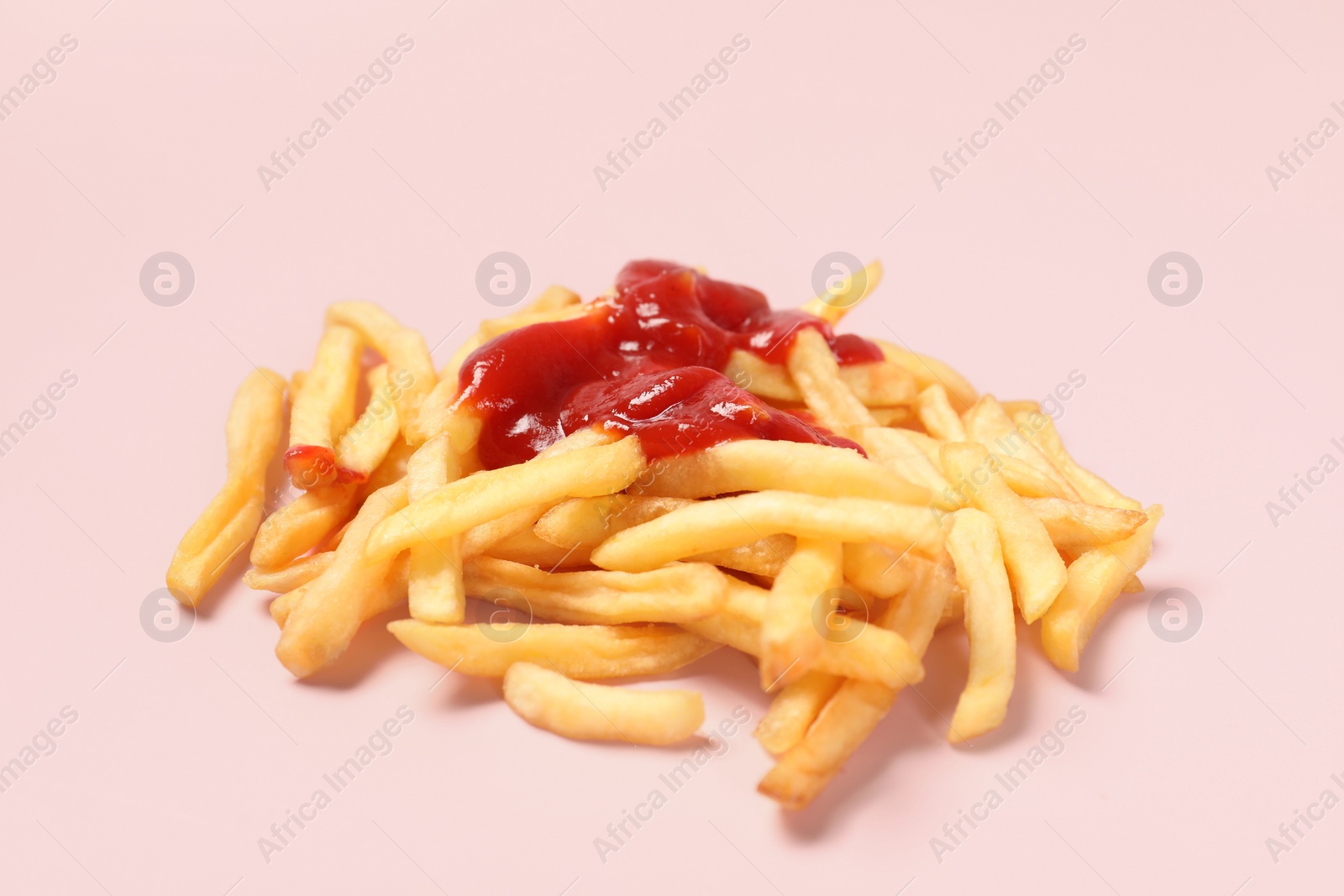 Photo of Tasty french fries with ketchup on pink background, closeup