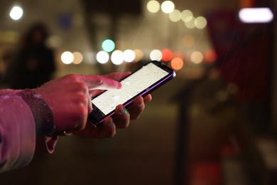 Photo of Man using smartphone on night city street, closeup. Space for text