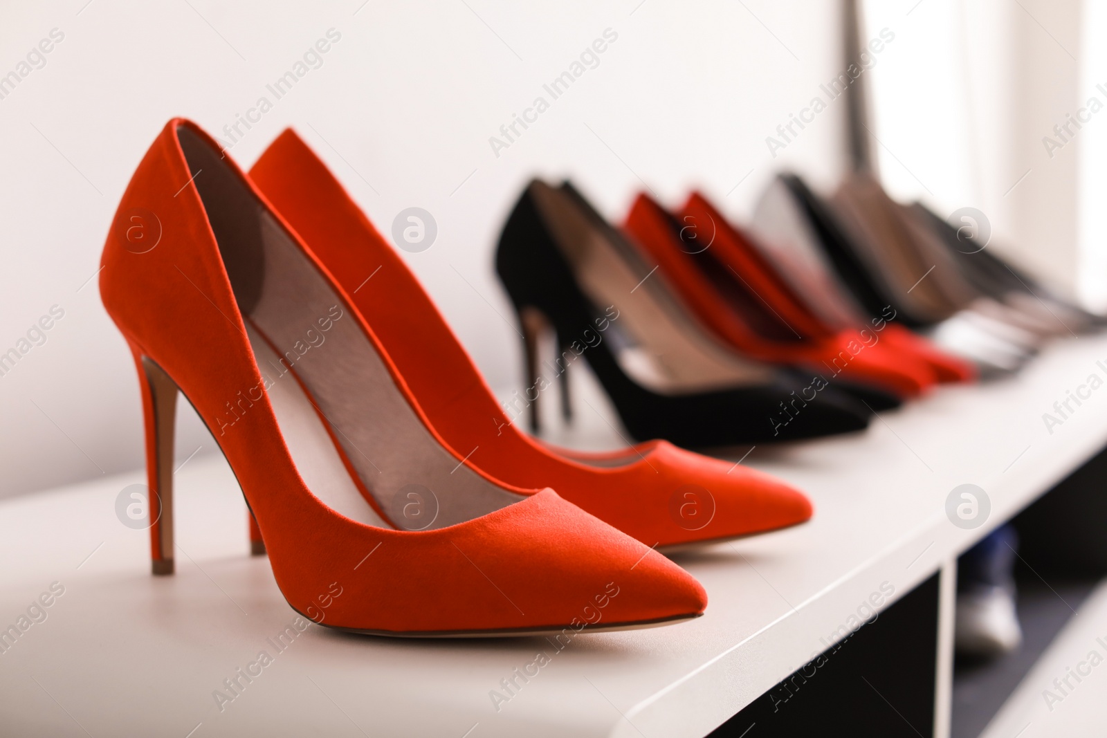 Photo of High heeled shoes on shelf in store