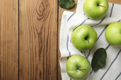 Flat lay composition of fresh ripe green apples on wooden background, space for text