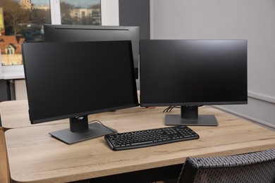 Photo of Modern interior. Workplace with multi-monitor on wooden desk in office, space for text