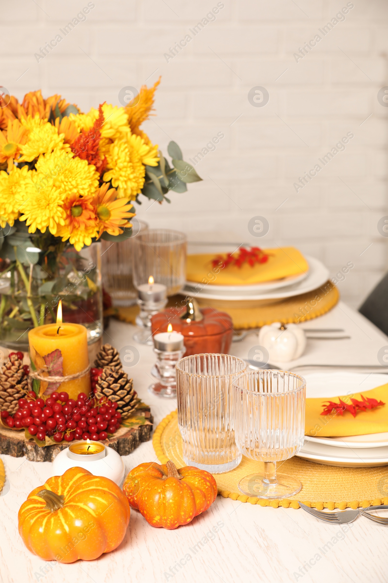 Photo of Autumn table setting with floral decor and pumpkins indoors