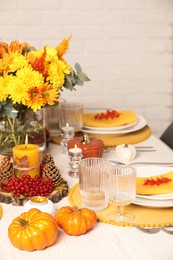 Autumn table setting with floral decor and pumpkins indoors