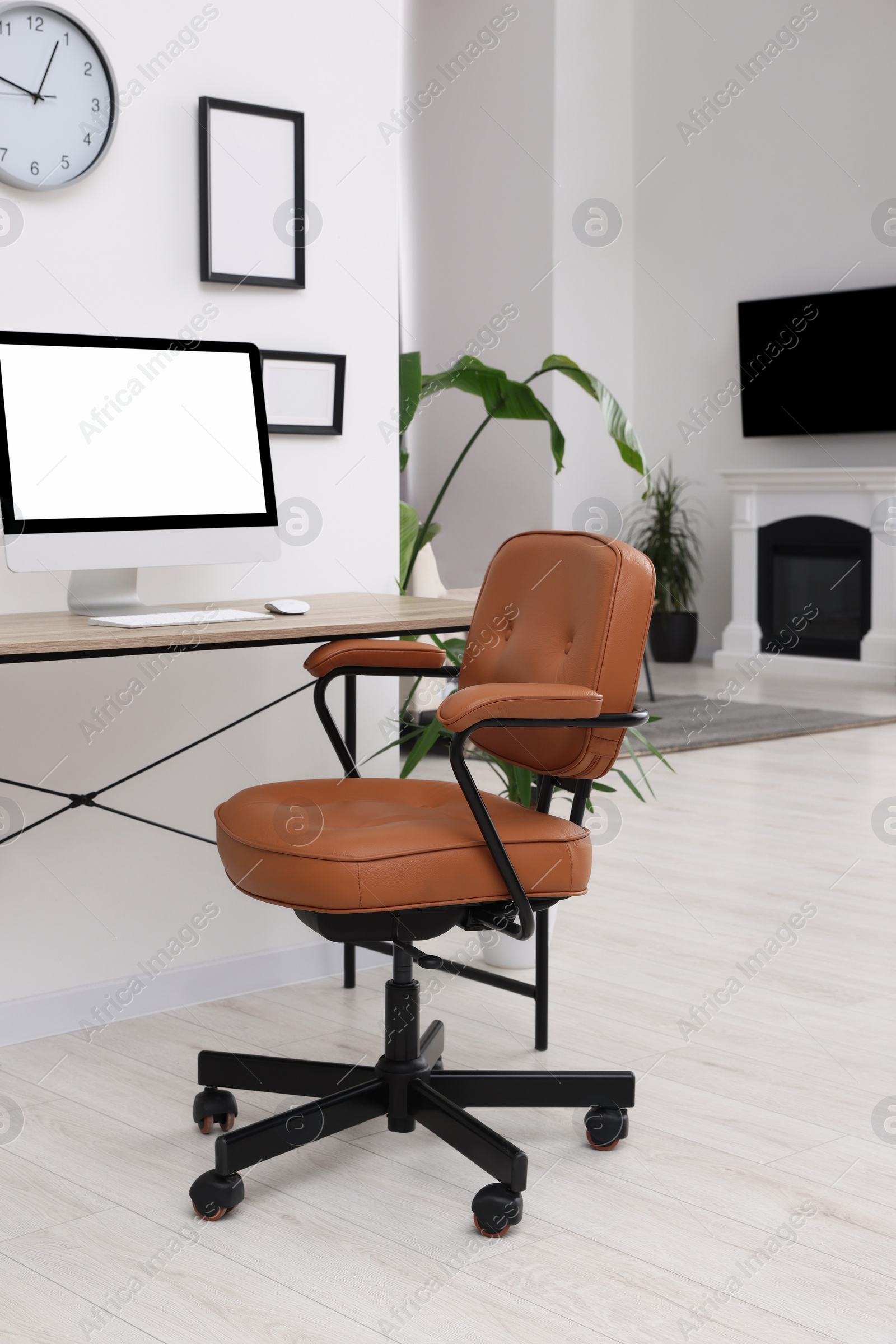 Photo of Stylish room interior with comfortable office chair, desk and houseplants