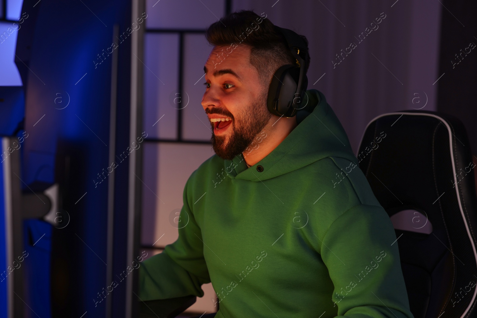 Photo of Man playing video games on computer indoors