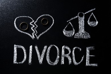 Wedding rings, word Divorce, broken heart and scales of justice drawn on blackboard, flat lay