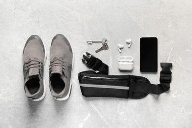 Photo of Flat lay composition with black waist bag on light grey table