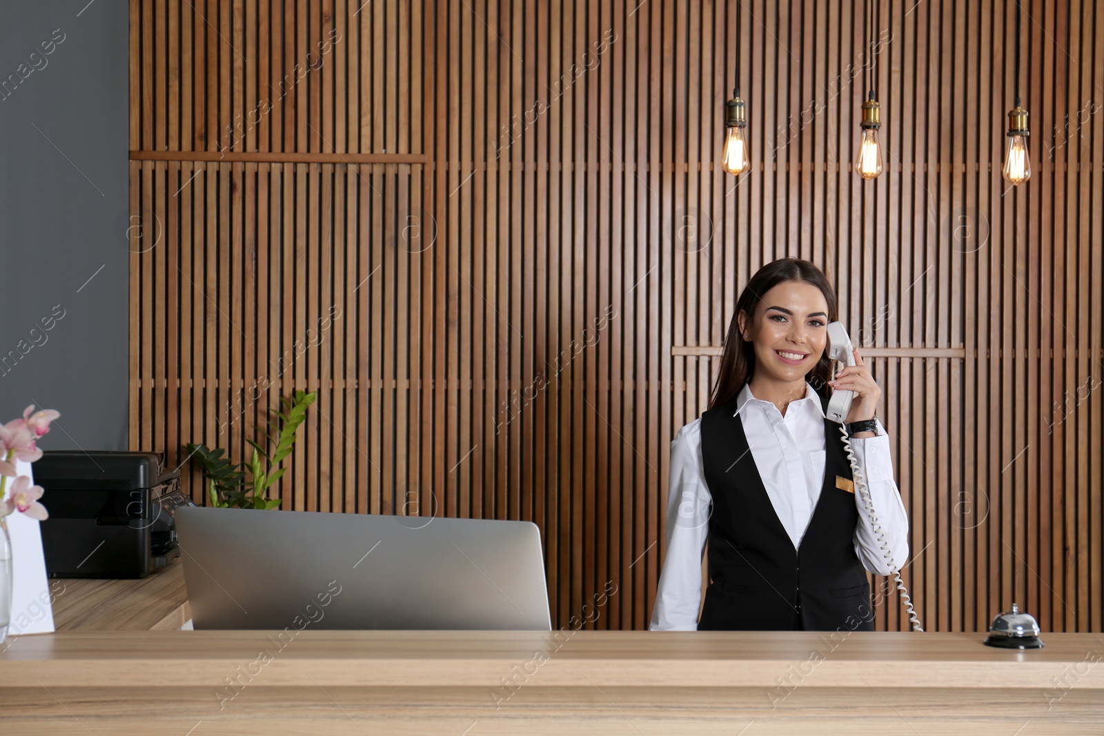 Photo of Receptionist talking on phone at desk in lobby
