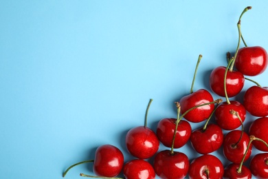 Photo of Composition with sweet cherries on light blue background, top view. Space for text