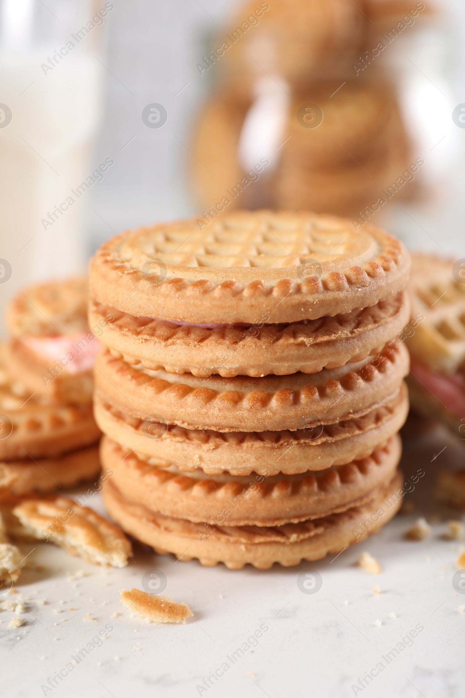 Photo of Tasty sandwich cookies with cream on white marble table, closeup