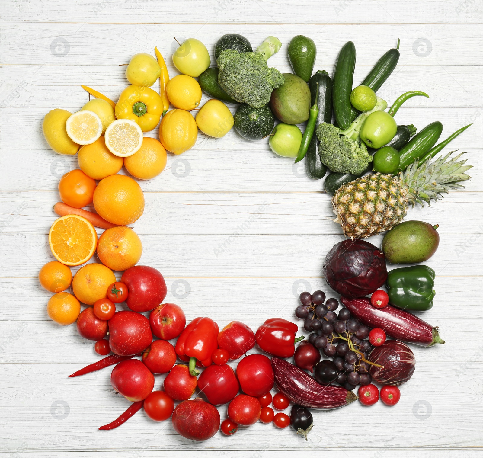 Photo of Rainbow frame made of fresh fruits and vegetables on wooden background