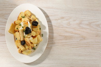 Tasty homemade parsnips with prunes and thyme on white wooden table, top view. Space for text