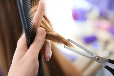 Professional hairdresser working with client in salon