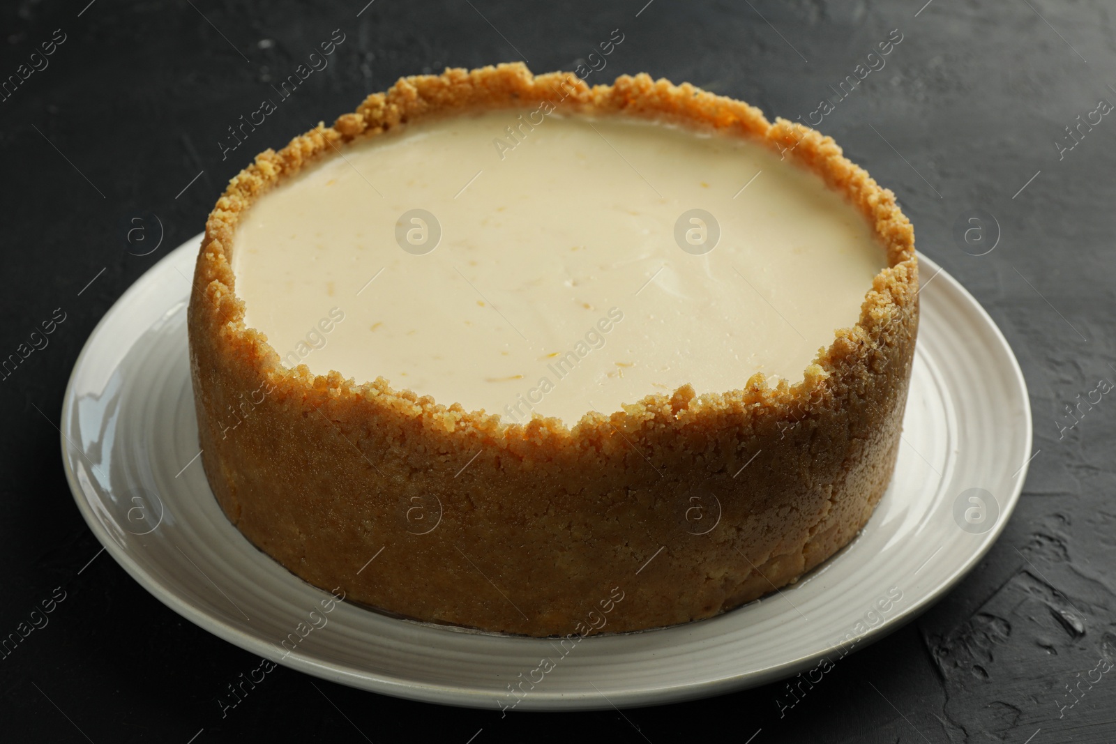 Photo of Tasty vegan tofu cheesecake on dark table