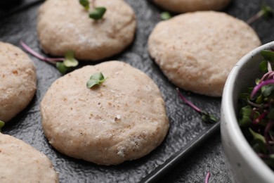 Photo of Raw vegan nuggets and spices on slate plate, closeup