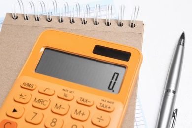 Photo of Calculator, notebook and pen on white table, closeup. Tax accounting