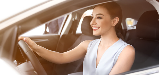 Happy young woman driving modern car on sunny day. Banner design