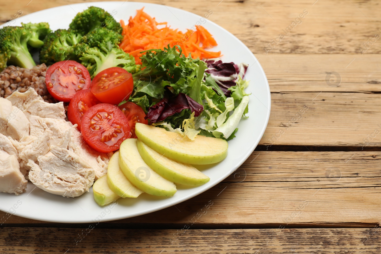 Photo of Balanced diet and healthy foods. Plate with different delicious products on wooden table, space for text