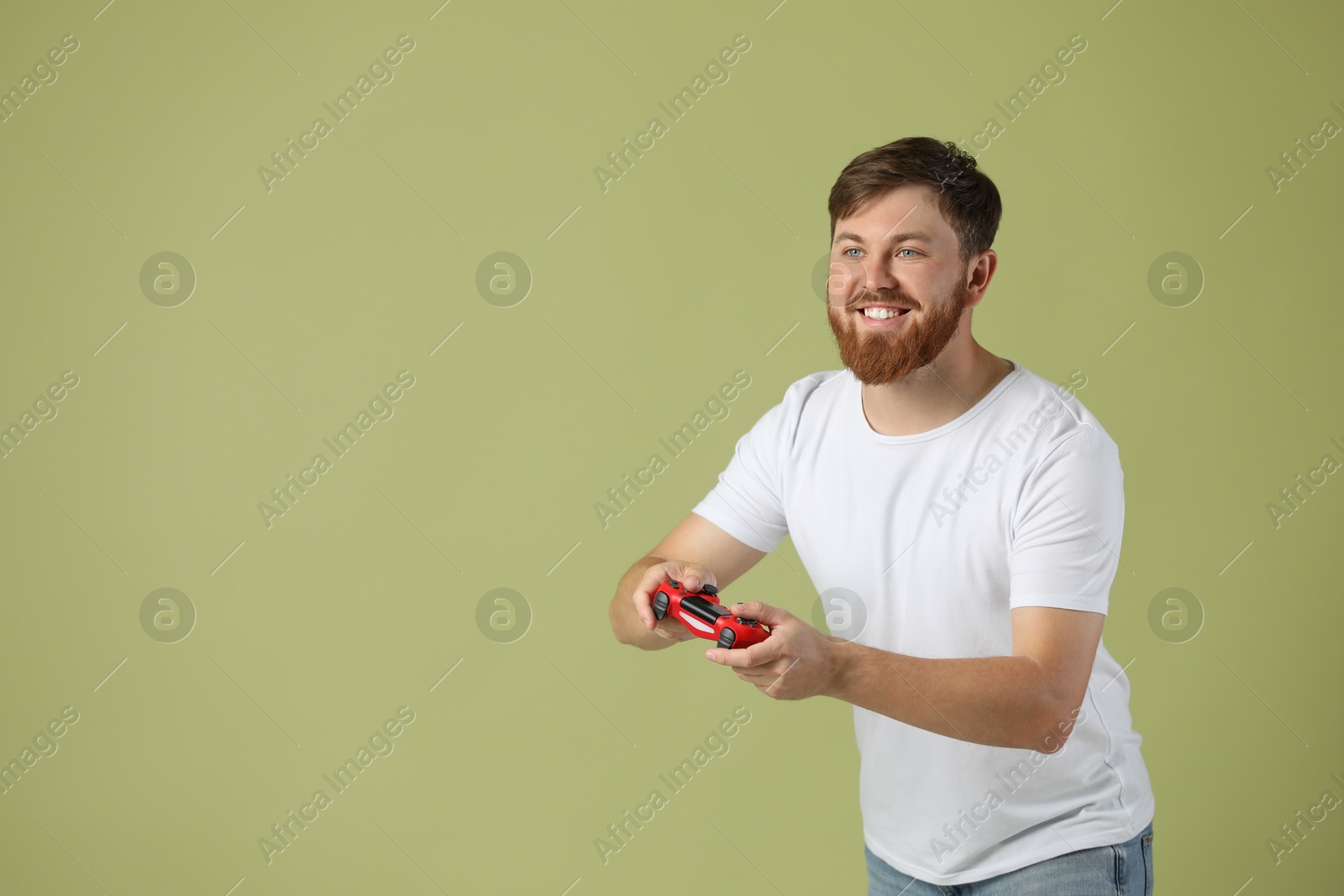 Photo of Happy man playing video game with controller on pale green background. Space for text