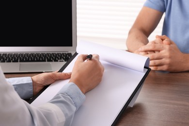 Photo of Doctor with clipboard in clinic, closeup. Patient consultation