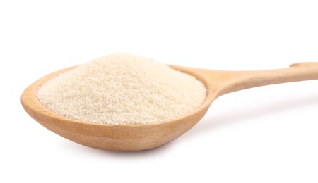 Spoon with organic semolina on white background, closeup