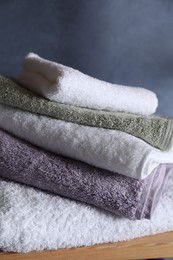 Photo of Stacked soft towels on wooden shelf indoors